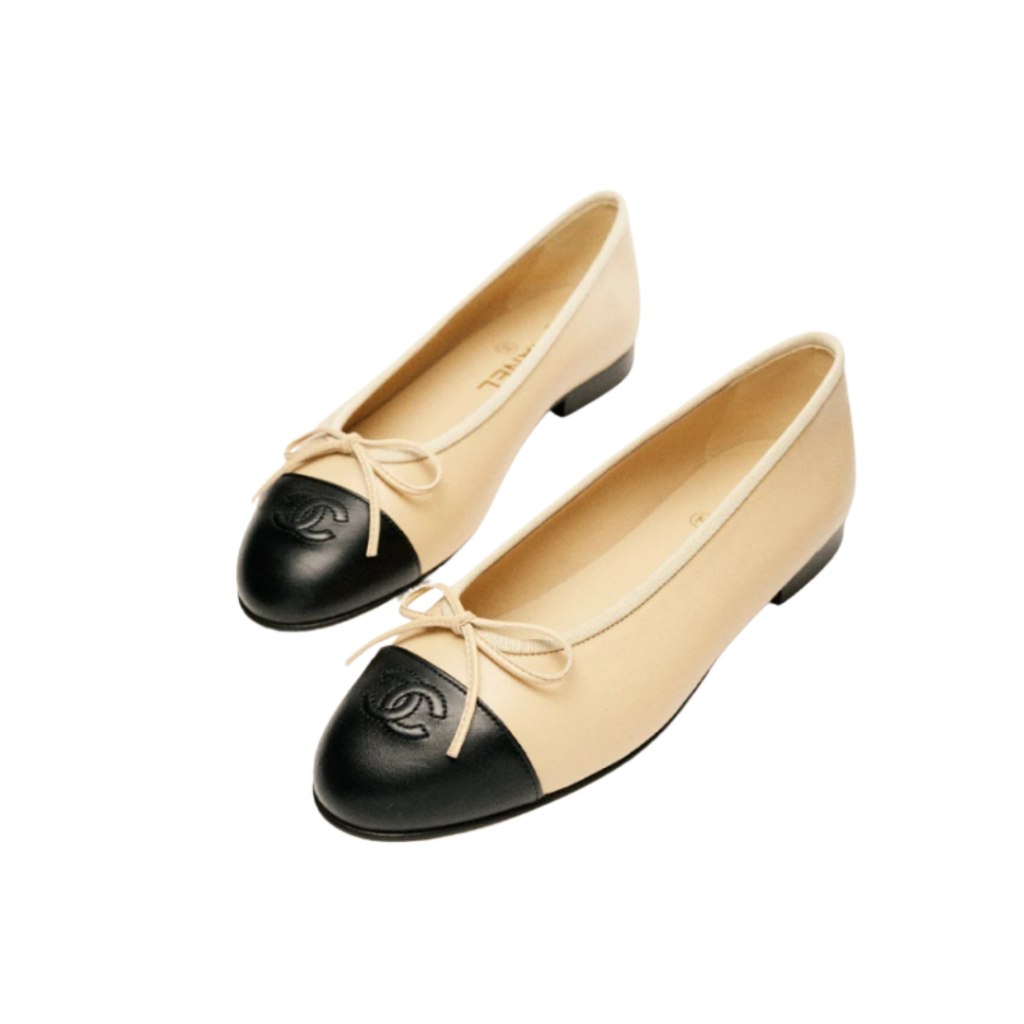CHANEL ballet flats crafted from beige lambskin with a contrasting black toe cap, featuring a classic round-toe silhouette and subtle grosgrain trim—embodying effortless Parisian chic.