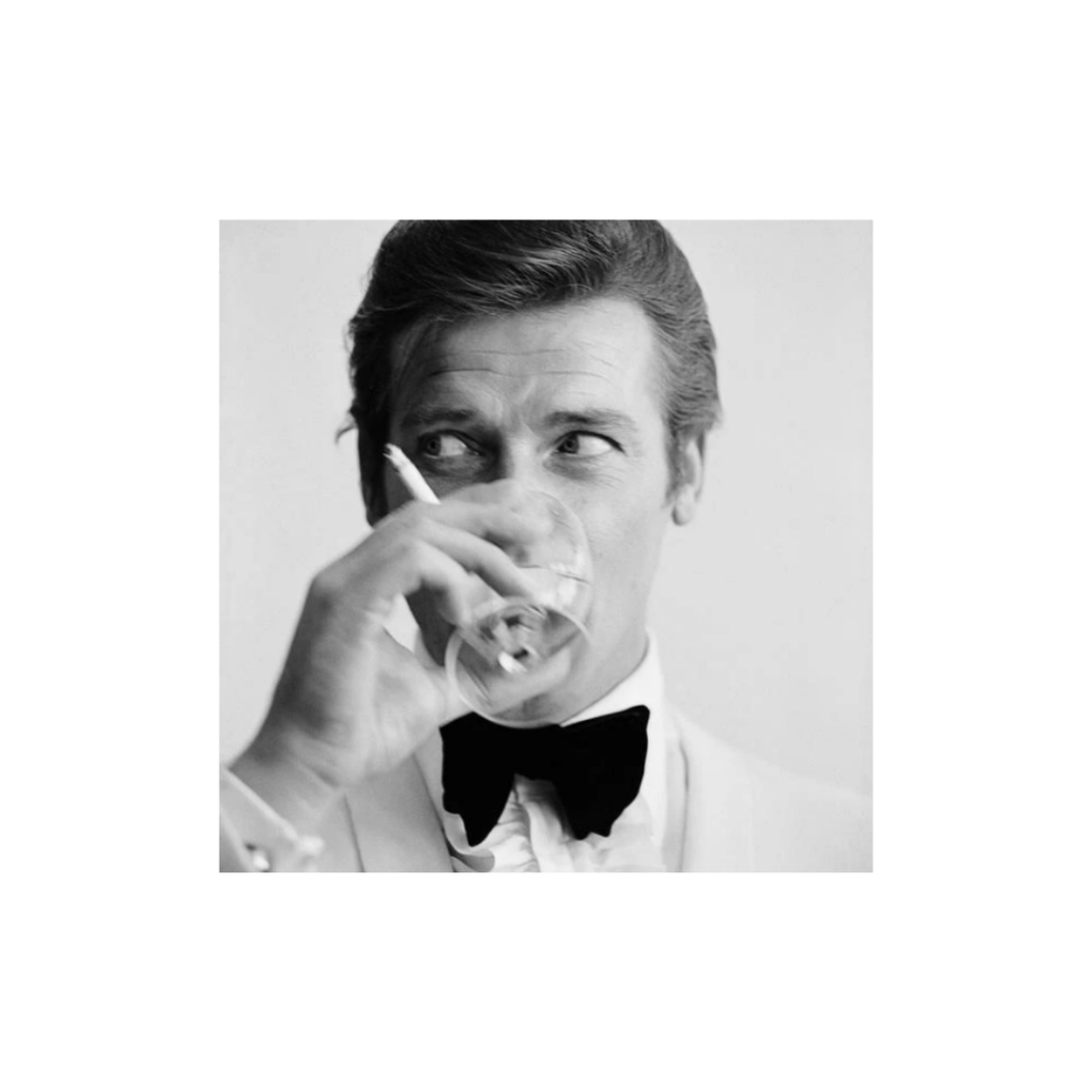 Framing To A T 'Shaken Not Stirred' print featuring a black-and-white portrait of actor Roger Moore sipping a martini in 1968, capturing a moment before his James Bond fame.​