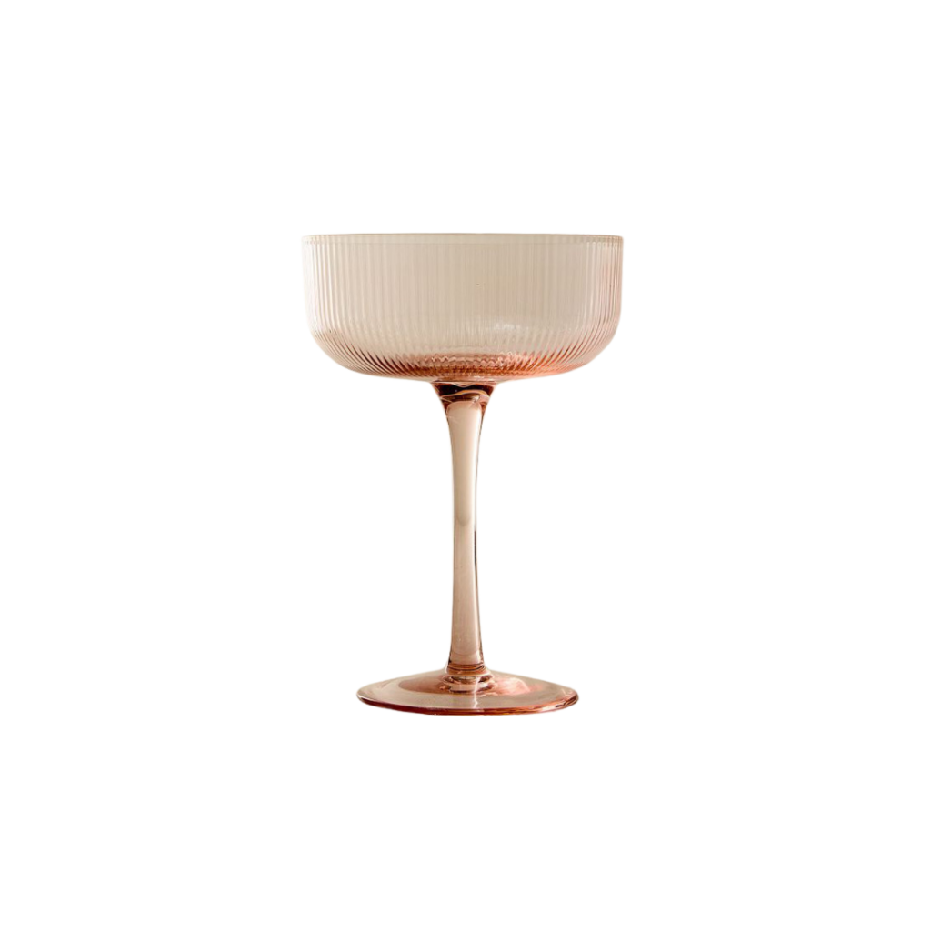A set of four blush-colored fluted coupe glasses, each featuring a delicate ribbed texture and a slender stem. These elegant glasses are perfect for serving champagne, cocktails, or desserts, adding a touch of sophistication to any occasion. Crafted from high-quality glass, they offer both style and functionality.