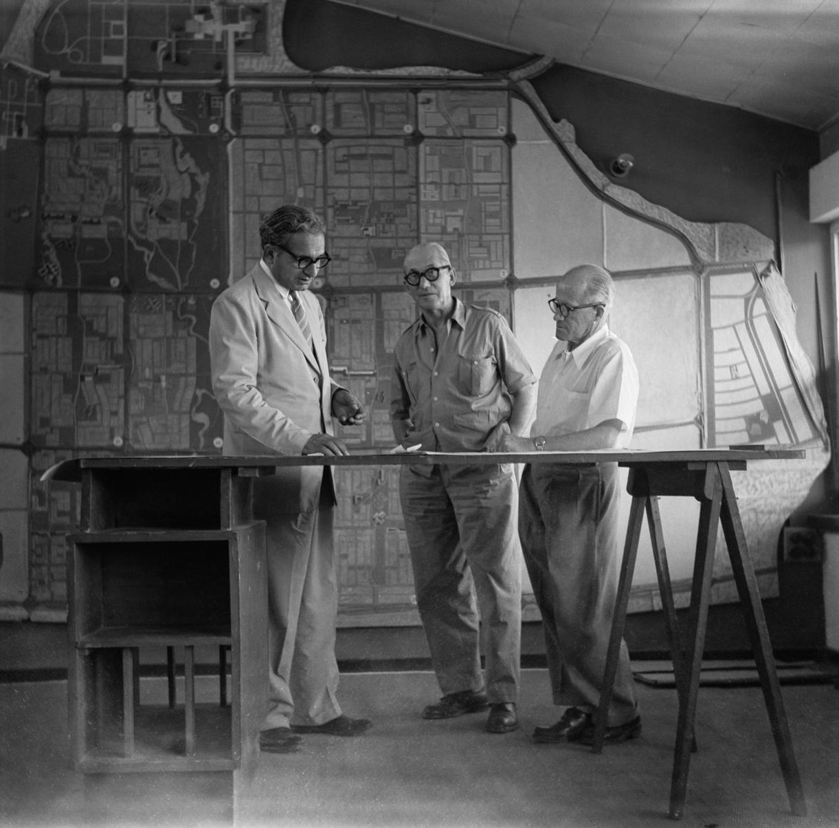 A black and white photograph from the 1950s showing Parmeshwari Lal Varma, Le Corbusier, and Pierre Jeanneret together.